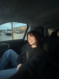 a woman sitting in the passenger seat of a car