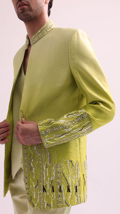 Injecting a dash of opulent flair to grandeur events is this fashionable open jacket set.
Accentuated on a base of linen satin this lime open jacket is adorned with hand embroidered cutdana accents and is elevated with stylish cuts.
Complemented with a waistcoat and straight pants this captivating ensemble will wrap you in sophistication and style. Cloth Collection, Bollywood Theme, Sangeet Outfit, Hijab Designs, Men's Ethnic Wear, Saree Blouse Patterns, Designer Suits For Men