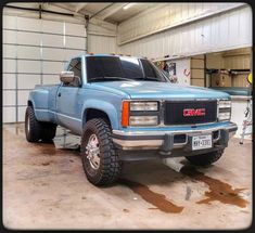 a blue truck parked inside of a garage