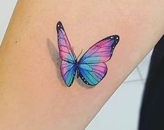 a colorful butterfly tattoo on the left side of the arm is shown in blue, pink and purple colors