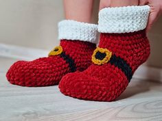 a close up of a person's feet wearing red crocheted slippers