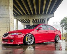 a red car is parked under an overpass