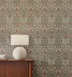 a lamp on a table next to a wall paper