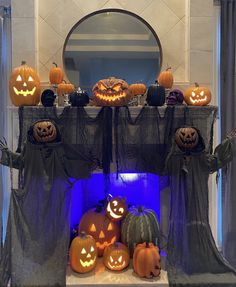 a fireplace decorated for halloween with pumpkins and jack - o'- lanternes