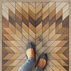 a person standing on top of a wooden floor next to a tiled flooring pattern