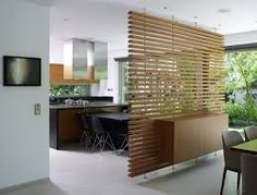 a modern kitchen with wooden slats on the wall and dining room table in the foreground