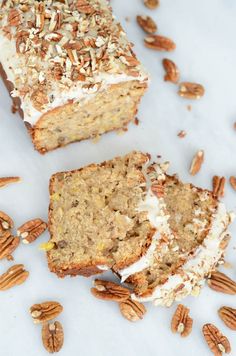 a loaf of cake with white frosting surrounded by pecans