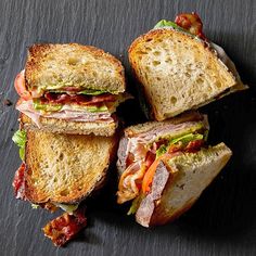 four sandwiches stacked on top of each other with bacon and lettuce in them