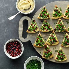 a platter filled with christmas tree shaped crackers next to bowls of dips