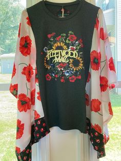 a black and white top with red flowers on it sitting on a window sill