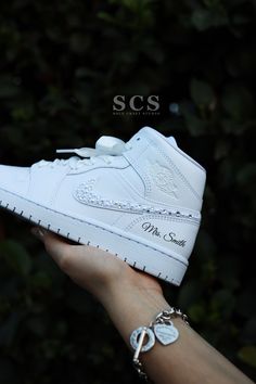 a person holding up a white nike air jordan shoe in their hand with the words scs on it