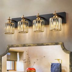 a bathroom vanity with three lights above it and a mirror on the wall next to it