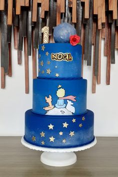 a three tiered blue cake with winnie the pooh on top and stars around it