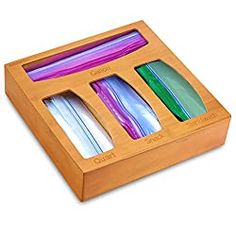 an open wooden box with four different colored items in it, including pens and pencils