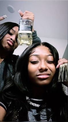 two women are holding up bottles of hair