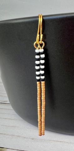 These lightweight beaded earrings are super comfortable to wear. Each earring was beaded with mini black, white and gold seed beads. They hang from gold plated stainless steel ear wires. Thectital length is 2.5 inches long. Thanks for checking out my earrings! Check out my other earrings here: https://www.etsy.com/shop/MonarchJewelryPeoria?ref=hdr_shop_menu§ion_id=8085181 Here's a link to the rest of my etsy shop: https://www.etsy.com/shop/MonarchJewelryPeoria?ref=seller-platform-mcnav Black And White Seed Bead Earrings, Minimalist White Beaded Earrings With Tiny Beads, Minimalist White Earrings With Tiny Beads, Minimalist White Beaded Dangle Earrings, Minimalist White Beaded Drop Earrings, Monarch Jewelry, Jewelry 2023, Stick Earrings, Bead Bar