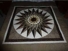 a quilted table topper with a star design on it's center piece