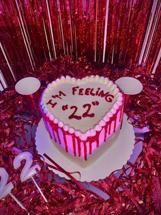 a heart shaped cake with the number twenty two on it sitting in front of red tinsel