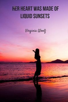 a woman standing on top of a beach next to the ocean under a purple sky