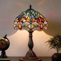 a lamp sitting on top of a table next to a clock