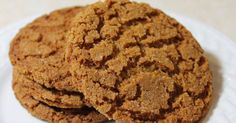 two cookies on a white plate sitting on a table