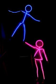 two neon stick figures in the dark with one pointing at another person's head