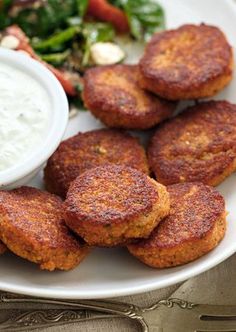 some fried food on a white plate with ranch dressing