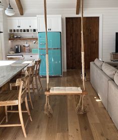 a living room filled with furniture and a blue refrigerator