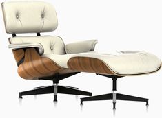 an eames lounge chair and ottoman in white leather with wood trim on the back