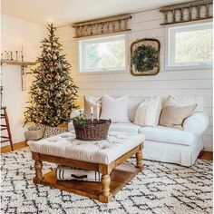 a living room with a christmas tree in the corner and a couch next to it