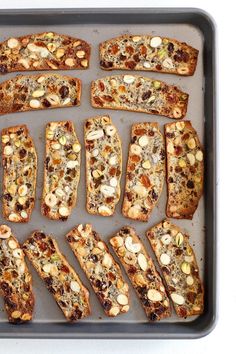 several slices of bread with nuts and other toppings on a baking sheet, ready to be baked