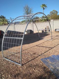 a metal structure sitting in the middle of a dirt field