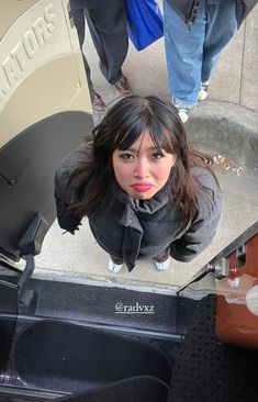 a woman standing in front of an escalator looking up at the camera