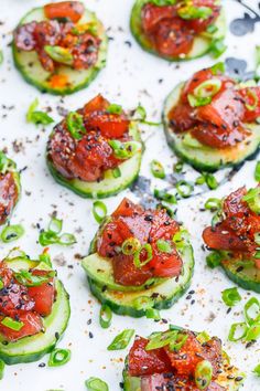 cucumbers with tomatoes, green onions and seasoning on them are ready to be eaten