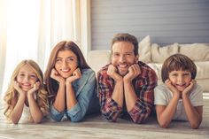 a man and two children laying on the floor with their hands under their chins