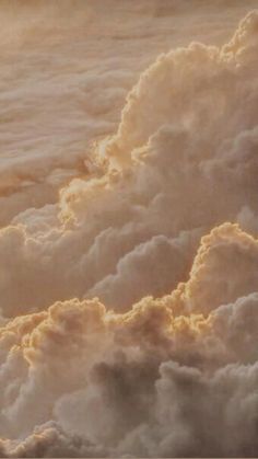 an airplane flying in the sky above some clouds