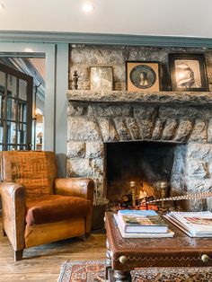 a living room filled with furniture and a fire place in front of a stone fireplace