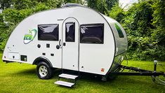 a small camper trailer parked in the grass