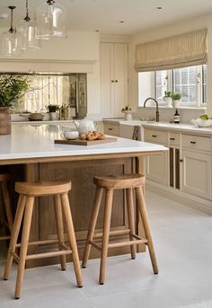 two wooden stools sit at the center of a kitchen island