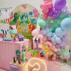 there are many balloons and decorations on the table for children's birthdays at this party