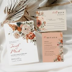 wedding stationery with flowers and feathers on top