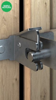 a close up of a metal door hinge on a wooden door with a green sticker