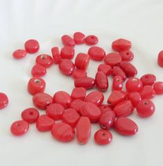 red beads are scattered on a white surface