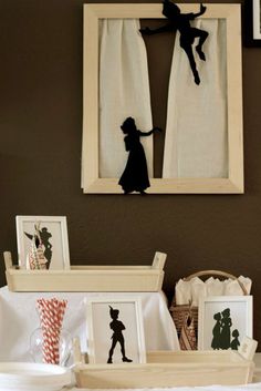 the silhouettes of two people are on display in front of framed pictures and other decorations