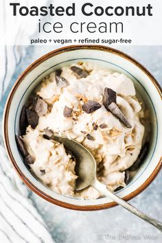 a bowl of toasted coconut ice cream with chocolate chips on top and a spoon in it