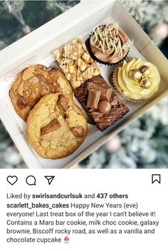 a box filled with lots of different types of cookies and muffins next to a christmas tree