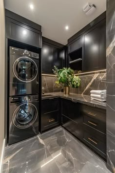 a washer and dryer in a room with black cabinets, marble counter tops