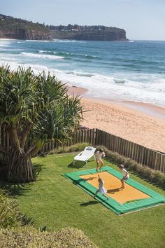 two people are playing on an inflatable mat near the beach