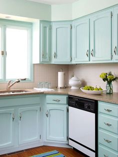 a kitchen with blue cabinets and a dishwasher in the middle of the counter