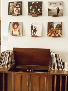 an old record player sitting on top of a wooden cabinet in front of a wall